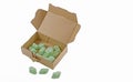 Open cardboard box with green packaging chips