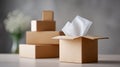 Open cardboard box with white tissue paper inside and stacked closed boxes in soft focus background on table Royalty Free Stock Photo