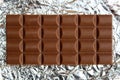 A bar of milk chocolate lies on the foil