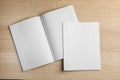 Open and closed blank brochures on wooden background, top view. Royalty Free Stock Photo