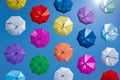 Open colorful umbrellas flying in clear blue sky