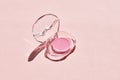 Open container with pink lip gloss or balm on a pink background. Royalty Free Stock Photo