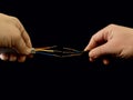 Open copper wires in a male hand. Electro wiring in hands, on a black background. Electrician