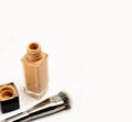 An Open Cosmetic Foundation Bottle with Blur Cap and Brush on White Background.