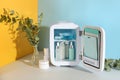 Open cosmetic refrigerator and skin care products on color background