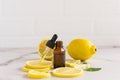 Open cosmetic vial with a dropper dropper filled with cosmetic lemon oil on a white marble background. lemon slices, melisa leaves Royalty Free Stock Photo
