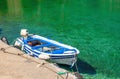 Open deck motor boat in color of Greek flag moored in cosy