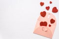 Open decorative pink envelope with red hearts flying out of it, Shiny bright background with space for wishes