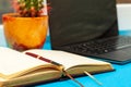 Open diary and laptop on a blue table Royalty Free Stock Photo