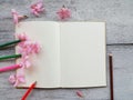 open diary and pencil pink flower on wood background Royalty Free Stock Photo