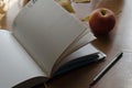 An open diary,  ripe apple and fallen leaves on the desk Royalty Free Stock Photo