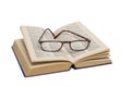 Open dictionary with glasses on white background.
