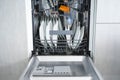 Open dishwasher with clean dishes in the home kitchen, front view Royalty Free Stock Photo