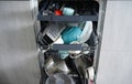 Dishwasher, open and loaded with dishes in the kitchen, after washing, close-up Royalty Free Stock Photo