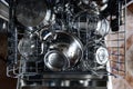 An open dishwasher with clean dishes in the kitchen. Royalty Free Stock Photo