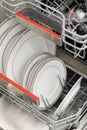 Open dishwasher with clean dishes in a white kitchen Royalty Free Stock Photo