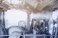 Open dishwasher with clean utensil inside, cutlery, glasses, dishes at kitchen Royalty Free Stock Photo