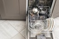 Open dishwasher with dirty dishes, plates, spoons, forks, cutlery, dishwasher tray Royalty Free Stock Photo