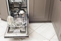 Open dishwasher with dirty dishes, plates, spoons, forks, cutlery, dishwasher tray Royalty Free Stock Photo