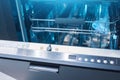 Open dishwasher door with settings and parameters for washing various dishes, water temperature and type of dishes Royalty Free Stock Photo