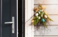 An open door and Easter decorations on wooden wall near the door. Happy Easter. Royalty Free Stock Photo