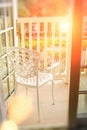 Open door to the balcony, where there is a white forged chair