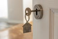 Open door to a new home with key and home shaped keychain. Mortgage, investment, real estate, property and new home concept Royalty Free Stock Photo
