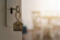 Open door to a new home with key and home shaped keychain. Mortgage, investment, real estate, property and new home concept Royalty Free Stock Photo