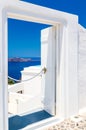 Open door to terrace with table and chair and beautiful view of sea and mountains in Oia, on Santorini island, Greece Royalty Free Stock Photo