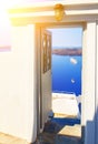 Open door to terrace with table and chair and beautiful view of sea and mountains in Oia, on Santorini island, Greece Royalty Free Stock Photo