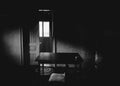 An open door, wooden table and a chair in a room of an old abandoned house. Light coming from the window, darkness horror concept.