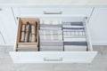 Open drawer with folded napkins and towels indoors. Order in kitchen