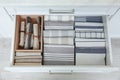 Open drawer with folded napkins and towels indoors. Order in kitchen