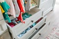 open drawers with clothes hanging out in a childs room Royalty Free Stock Photo