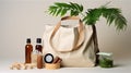 Open eco-friendly cotton reusable bag with different containers from natural wood and brown glass.Fresh natural leafs around.