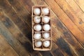 Open eco-friendly wooden box with eggs on diagonal wooden table.