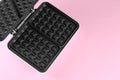Open electric waffle maker on pink background, top view. Space for text Royalty Free Stock Photo