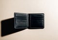 An open empty black leather wallet is displayed on a neutral beige background with multiple card slots visible Royalty Free Stock Photo