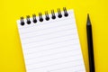 Open, empty blank notebook on a yellow background, spiral notepad on a table. Abstract concept, copy space Royalty Free Stock Photo