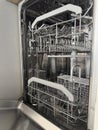 Open empty dishwasher with clean metal racks in a modern kitchen setting. Home Cleaning Routine Royalty Free Stock Photo