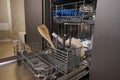 Open empty dishwasher in kitchen. Modern kitchen appliance. Housekeeping equipment, Household chores. Close-up Royalty Free Stock Photo