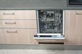 Open empty dishwasher in kitchen. Modern smart electronic housekeeping technology Royalty Free Stock Photo