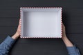 Open empty gift box in children`s hands on black background. Top view Royalty Free Stock Photo