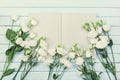 Open empty notebook and bouquet of white flowers eustoma on blue rustic table top view. Woman working desk. Flat lay. Royalty Free Stock Photo