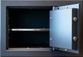 An open empty safe with a dark interior, featuring a cold metallic texture and visible shelf, captured in a close-up Royalty Free Stock Photo