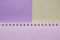 Open empty spiral notebook on a two-tone background of lilac and gray, top view, minimalism with a copy of the space with a blank