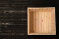 Open empty wooden crate on dark background, top view
