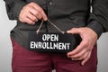 Open Enrollment concept. Miniature chalk board in a man& x27;s hands