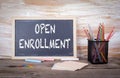 Open Enrollment text on a blackboard. Old wooden table with text