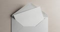 An open envelope with a visible white sheet of paper inside rests on a light wooden surface. The Royalty Free Stock Photo